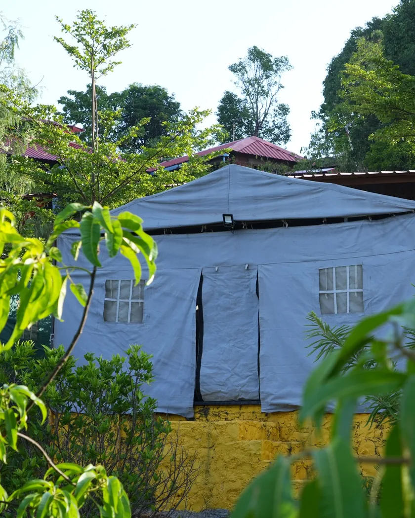 A big glamping tent among the trees at the farm campsite near Pune.