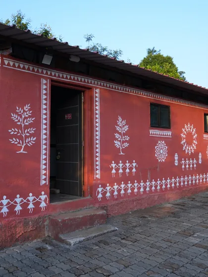 The shared washroom block for the tents, painted with white Warli figures.