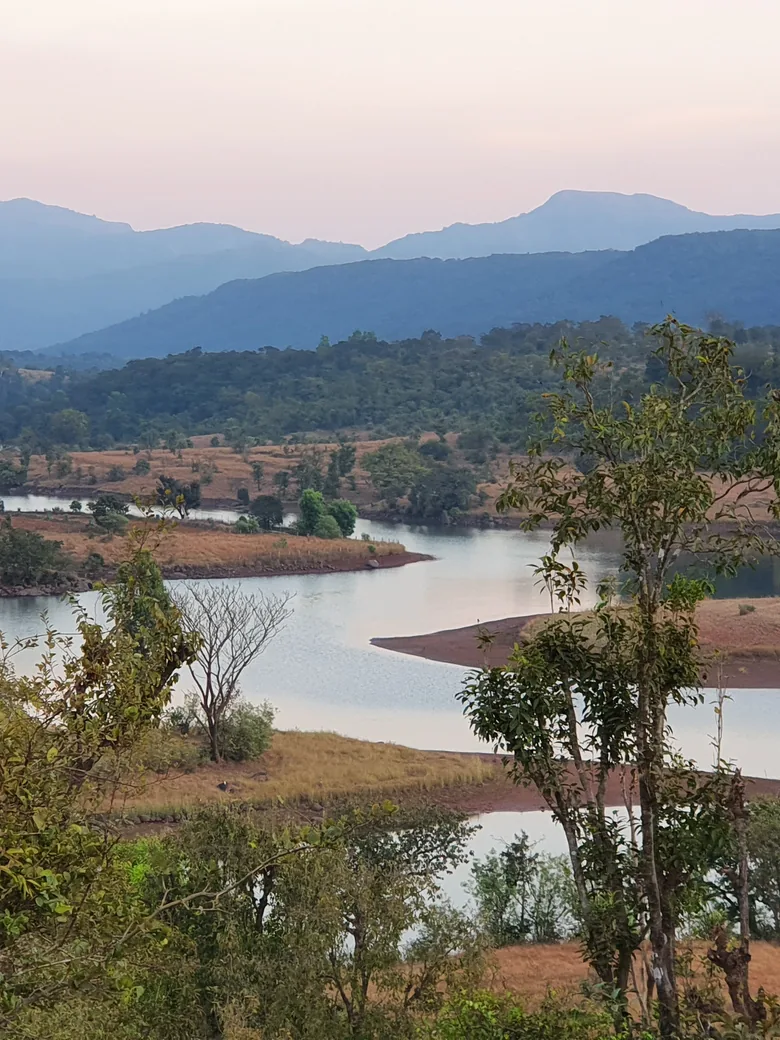 The river below the property at dusk, the Sahyadri ridgeline folding away behind it.