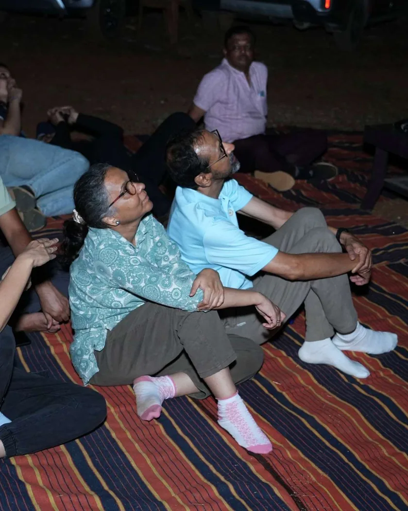 Guests lying back on mats on the farm at night, looking up at the sky.