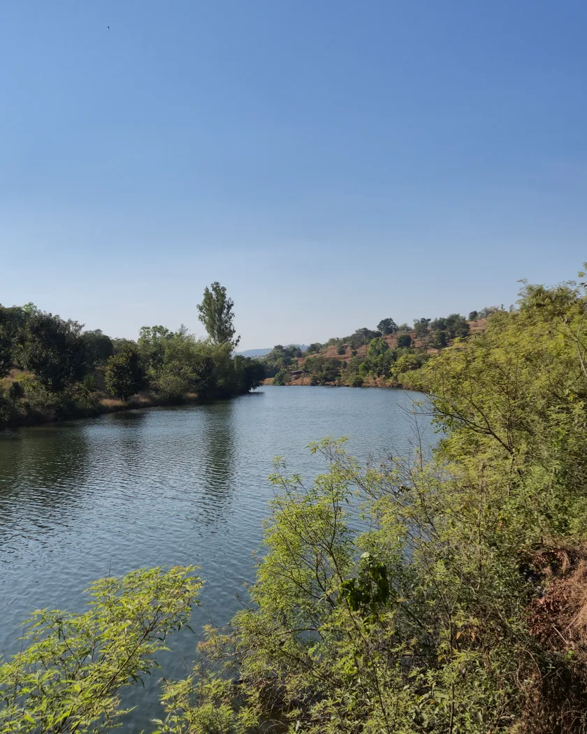 The river below the farm near Rajgad Fort, still between wooded banks.